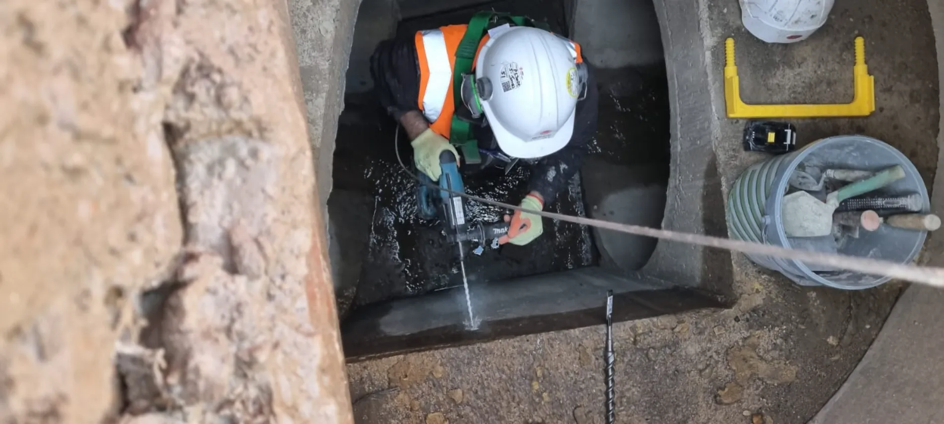 person drill hole in wall underground